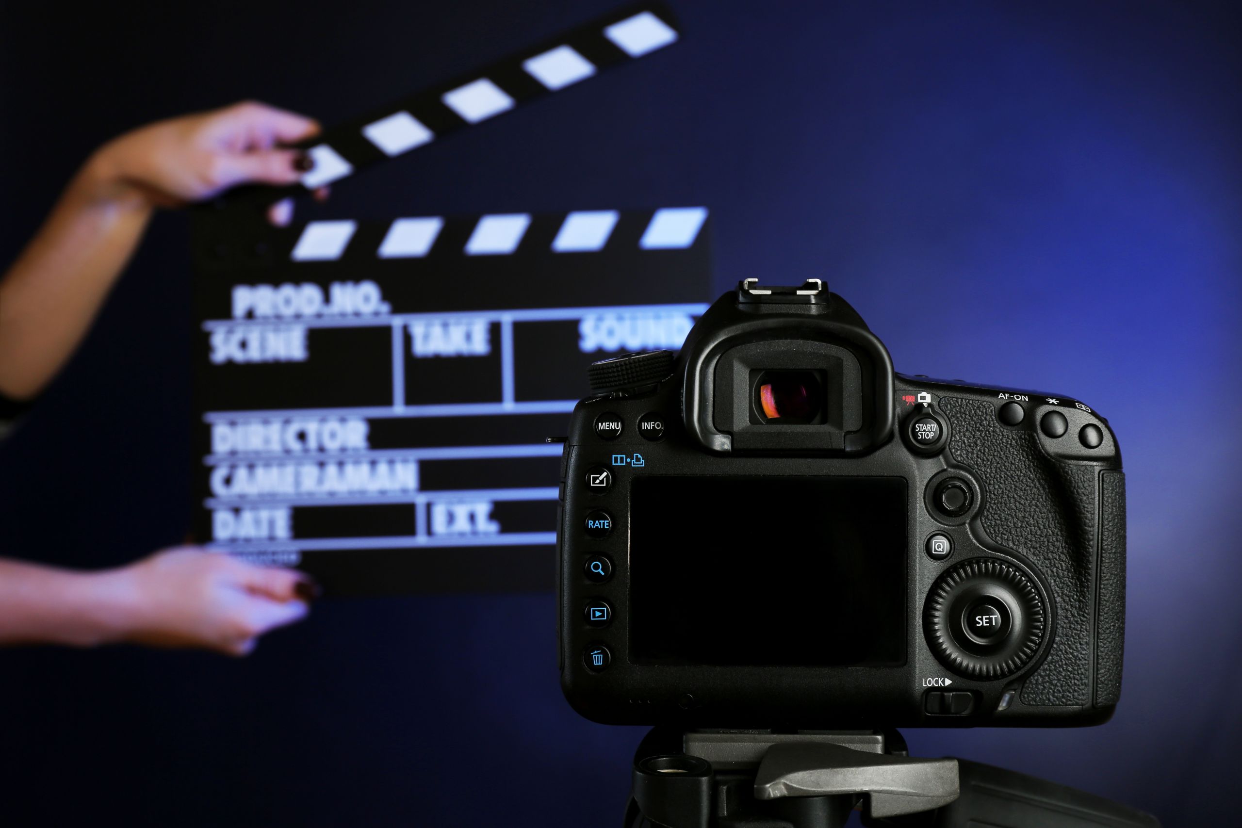 Videoçarx və Reels Çəkilişi 1 hands-with-movie-clapper-board-front-camera-dark-background
